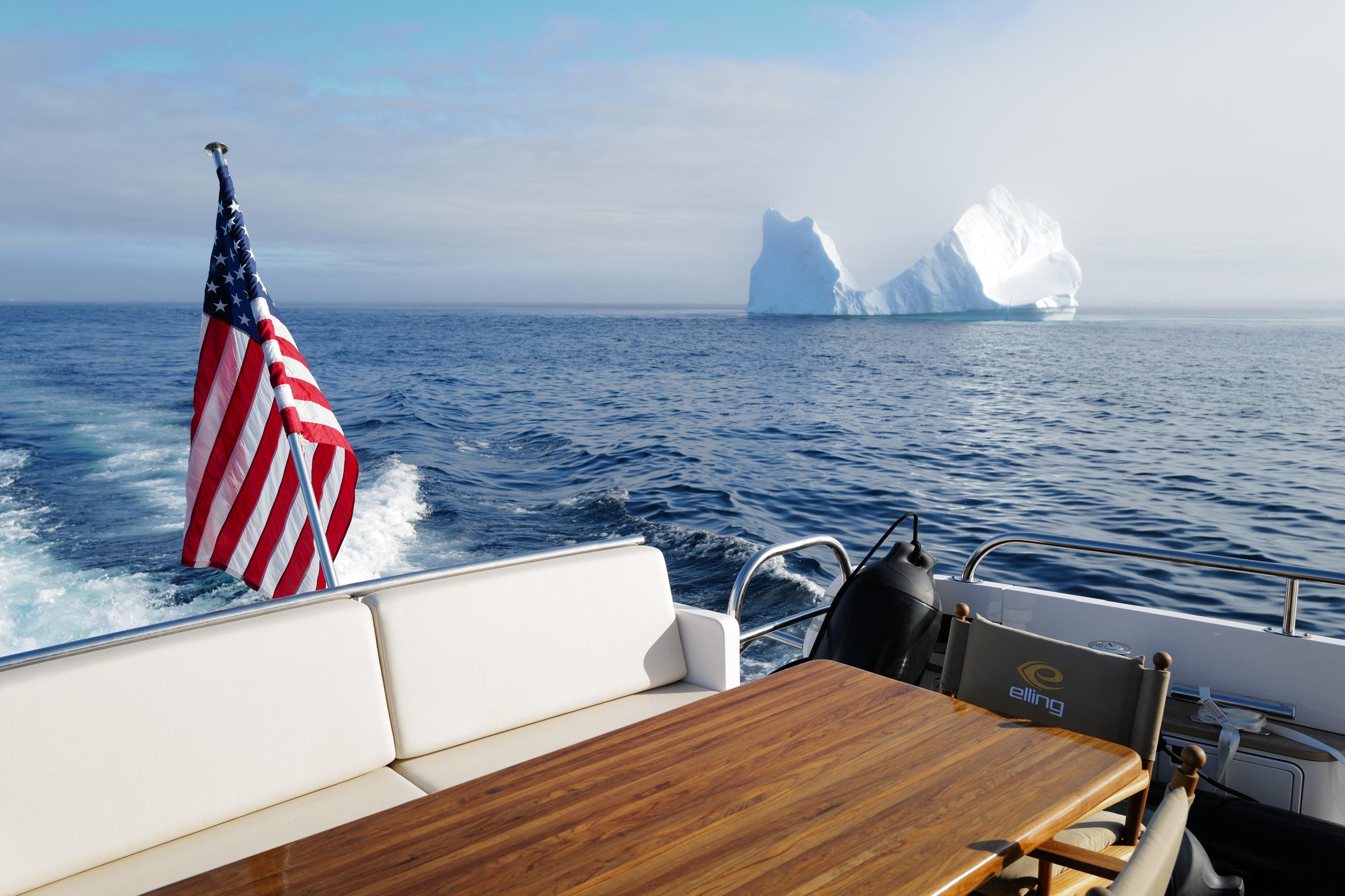 Elling E6 yacht with American flag, iceberg in background, 2021 model.