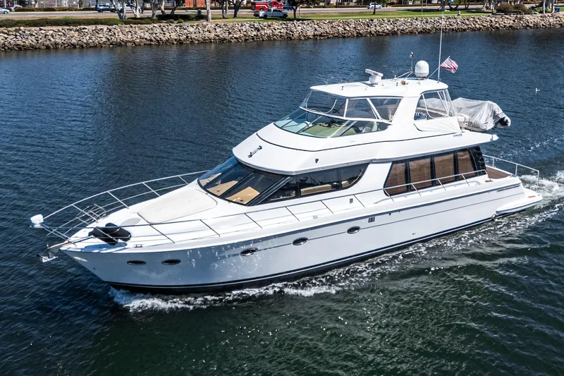  Yacht Photos Pics 2003 Carver 570 Voyager Pilothouse yacht cruising on a calm waterway.