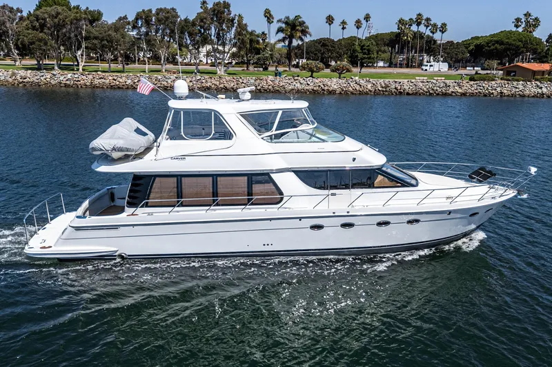  Yacht Photos Pics 2003 Carver 570 Voyager Pilothouse yacht cruising on a scenic waterway.