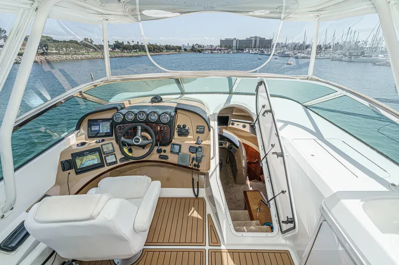  Yacht Photos Pics Interior view of 2003 Carver 570 Voyager Pilothouse helm with navigation equipment and waterfront backdrop.