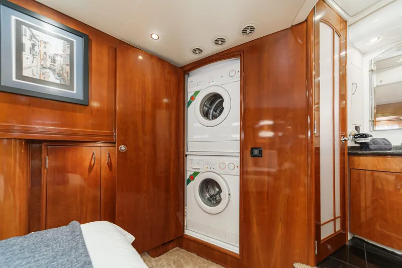  Yacht Photos Pics Laundry area in 2003 Carver 570 Voyager Pilothouse with wood cabinetry and stacked washer-dryer.