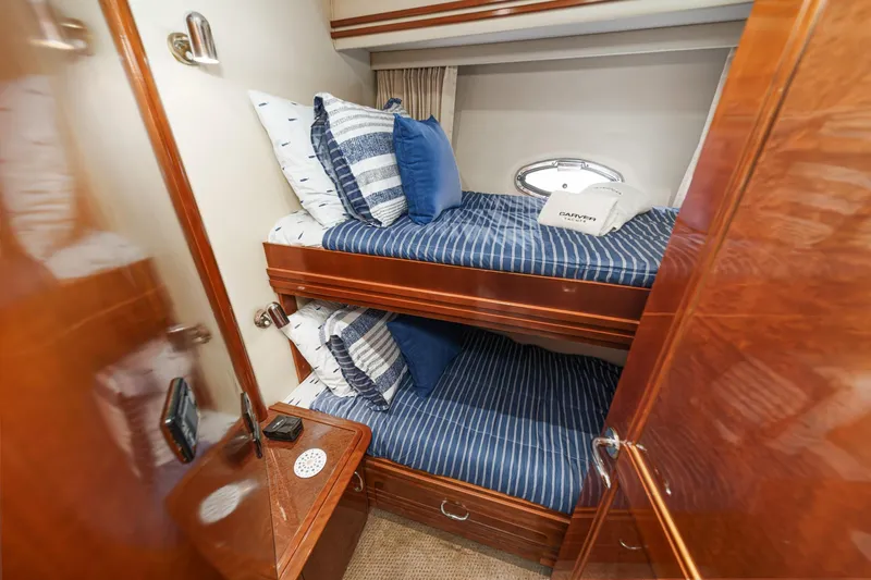  Yacht Photos Pics Bunk beds in 2003 Carver 570 Voyager Pilothouse with blue striped bedding and wooden cabinetry.