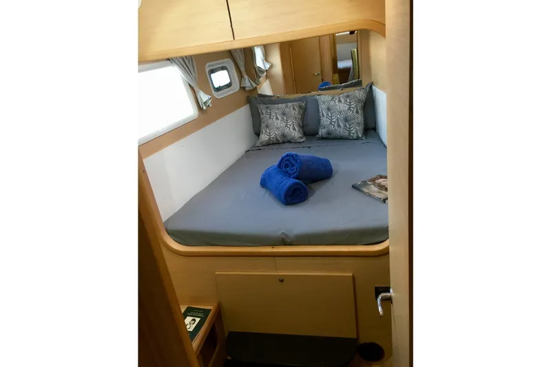 Rewind Yacht Photos Pics Cozy cabin interior of 2007 Lagoon 440 catamaran with bed and blue towels.