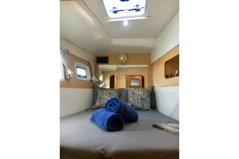 Rewind Yacht Photos Pics Cozy interior of 2007 Lagoon 440 catamaran with bed, pillows, and rolled towels.