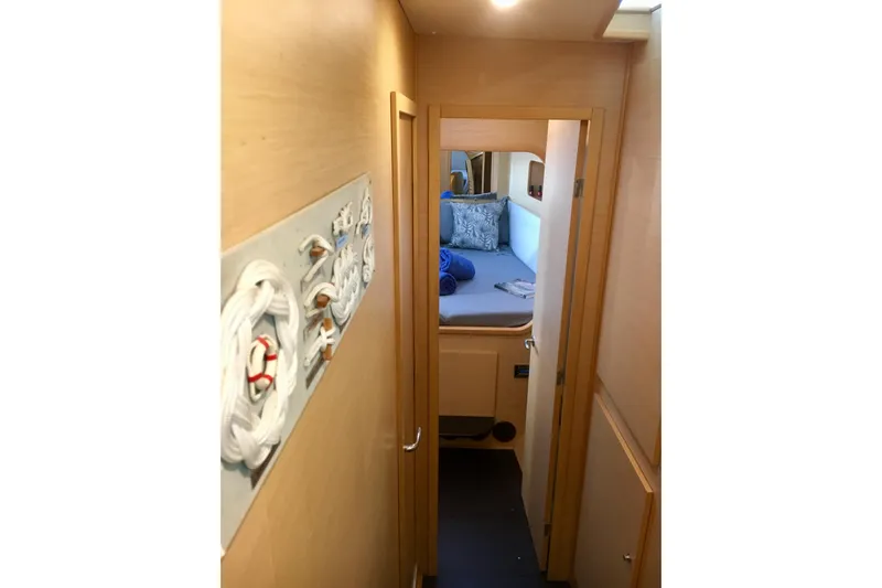 Rewind Yacht Photos Pics Interior hallway of 2007 Lagoon 440 yacht, leading to cozy bedroom with nautical decor.