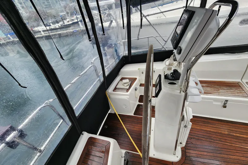 Danza Yacht Photos Pics 2007 Hanse 400e yacht cockpit with steering wheel and navigation equipment, docked on a rainy day.