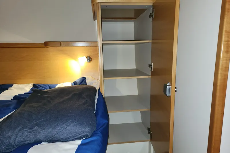 Danza Yacht Photos Pics Cozy cabin interior of 2007 Hanse 400e yacht with bed and wooden shelving.