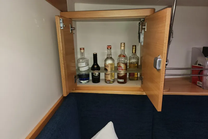 Danza Yacht Photos Pics Wooden cabinet on Hanse 400e yacht, displaying assorted liquor bottles, 2007 model.