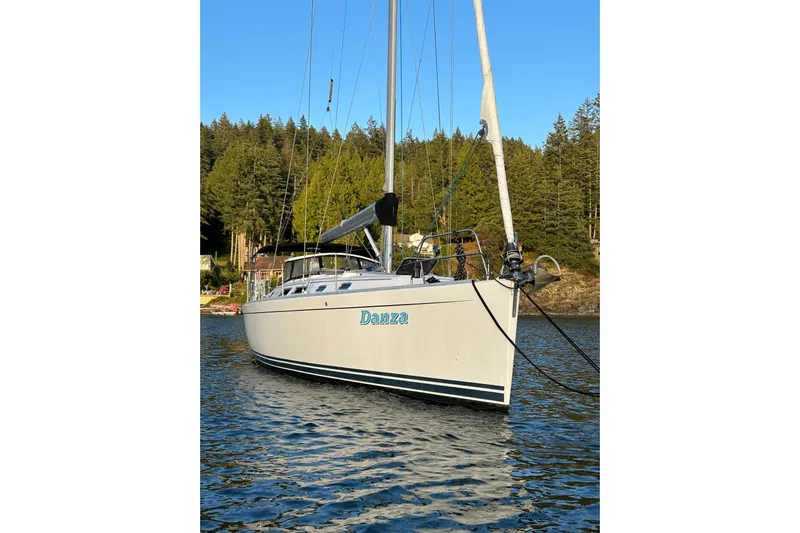 Danza Yacht Photos Pics 2007 Hanse 400e sailboat named Danza on calm water, surrounded by trees.