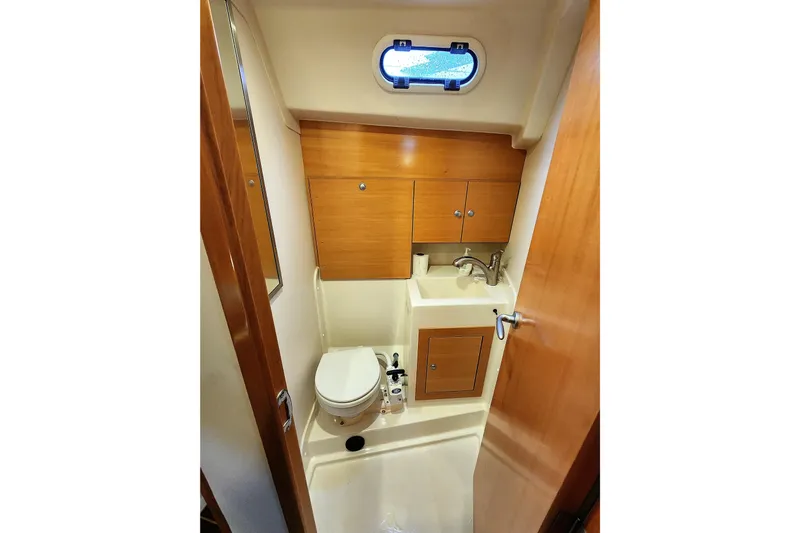 Danza Yacht Photos Pics 2007 Hanse 400e yacht bathroom with wooden cabinets, sink, and toilet.