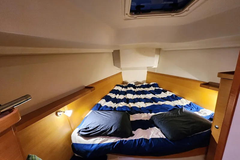 Danza Yacht Photos Pics Cozy cabin interior of 2007 Hanse 400e sailboat with striped bedding and soft lighting.