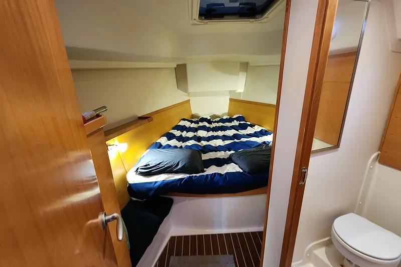Danza Yacht Photos Pics Cozy cabin interior of 2007 Hanse 400e sailboat with striped bedding and compact bathroom.