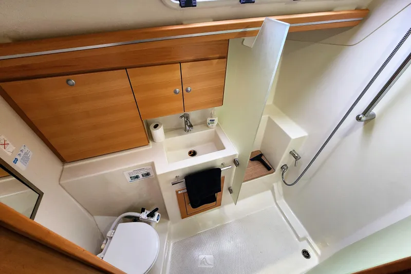 Danza Yacht Photos Pics 2007 Hanse 400e yacht bathroom with wooden cabinets, sink, and shower area.