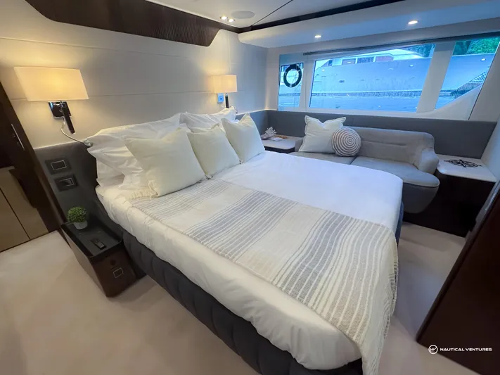 Fairline Phantom Yacht Photos Pics Luxurious bedroom interior of 2023 Fairline Phantom 65 yacht with elegant decor and large windows.