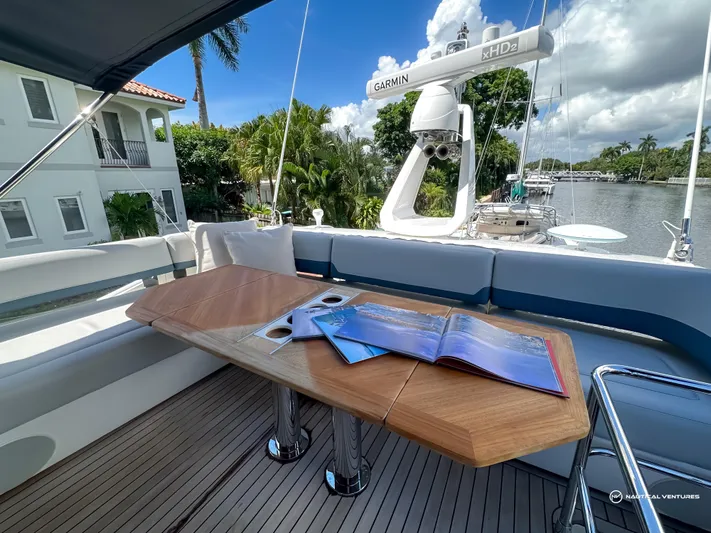 Fairline Phantom Yacht Photos Pics 2023 Fairline Phantom 65 yacht deck with wooden table and open magazine.