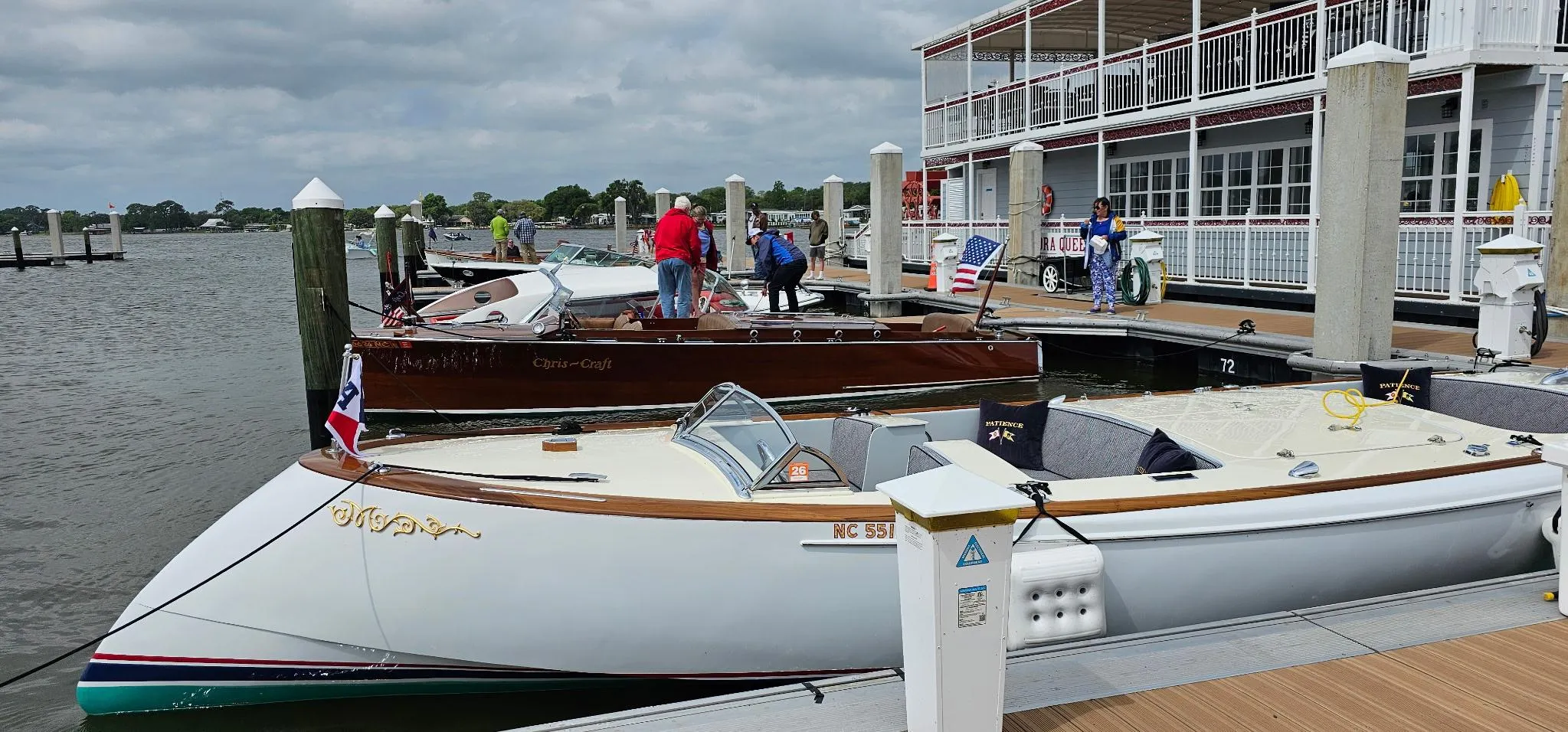 Boats docked at a marina with people on the pier, Custom M27 model, 2023.