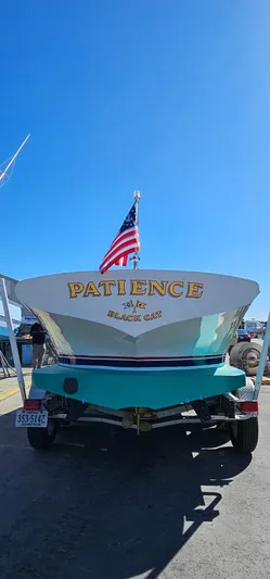 Patience Yacht Photos Pics Custom M27 boat named "Patience" with American flag, docked under clear blue sky.