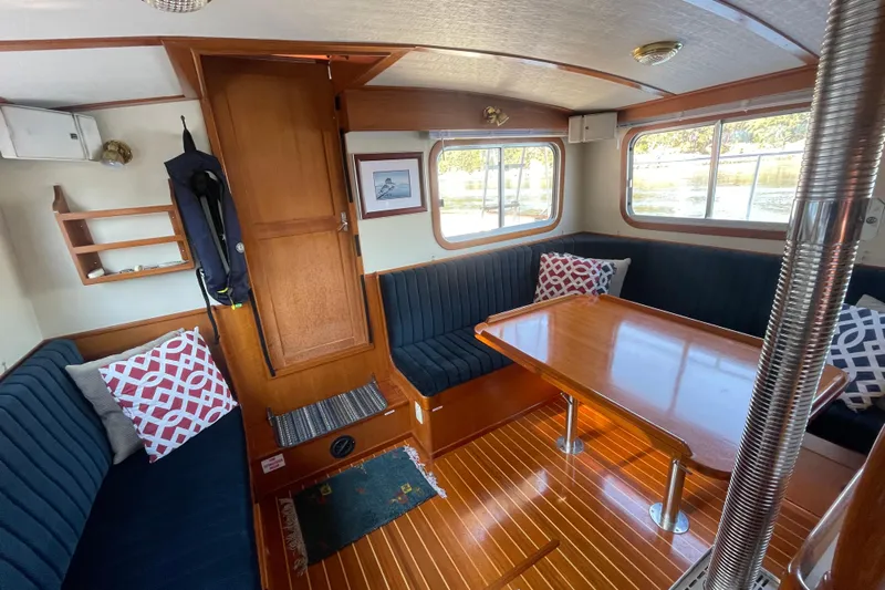 Honu Yacht Photos Pics Interior of 1994 Eagle 40 Pilothouse Trawler with wood table and blue seating.
