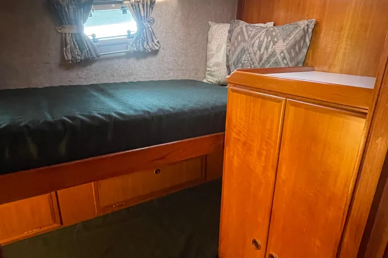Honu Yacht Photos Pics Cozy cabin interior of 1994 Eagle 40 Pilothouse Trawler with wooden cabinetry and bed.
