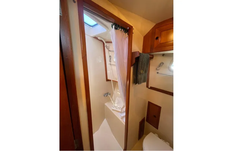 Honu Yacht Photos Pics Bathroom interior of 1994 Eagle 40 Pilothouse Trawler with shower and wooden cabinetry.