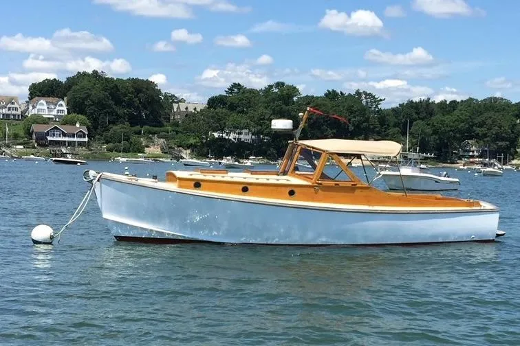 Ilona Yacht Photos Pics Custom Gannon & Benjamin 2005 boat on calm water, surrounded by scenic shoreline.