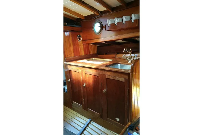 Ilona Yacht Photos Pics Wooden boat interior with sink, custom cabinetry, and porthole, Gannon & Benjamin, 2005 model.