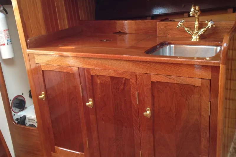 Ilona Yacht Photos Pics Wooden boat galley with brass faucet, stainless steel sink, and polished cabinetry, Custom Gannon & Benjamin 2005.