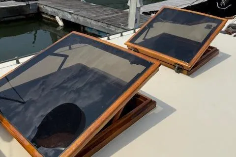 Ilona Yacht Photos Pics Custom Gannon & Benjamin 2005 boat hatches with wooden frames at a dock.