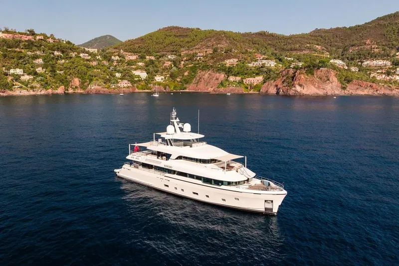 Kokoro Yacht Photos Pics Luxurious 2020 Moonen Martinique YN1 yacht cruising near scenic coastal landscape.