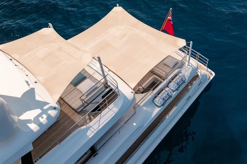 Kokoro Yacht Photos Pics Luxury yacht Moonen Martinique YN1, 2020 model, with sunshade and flag on open sea.
