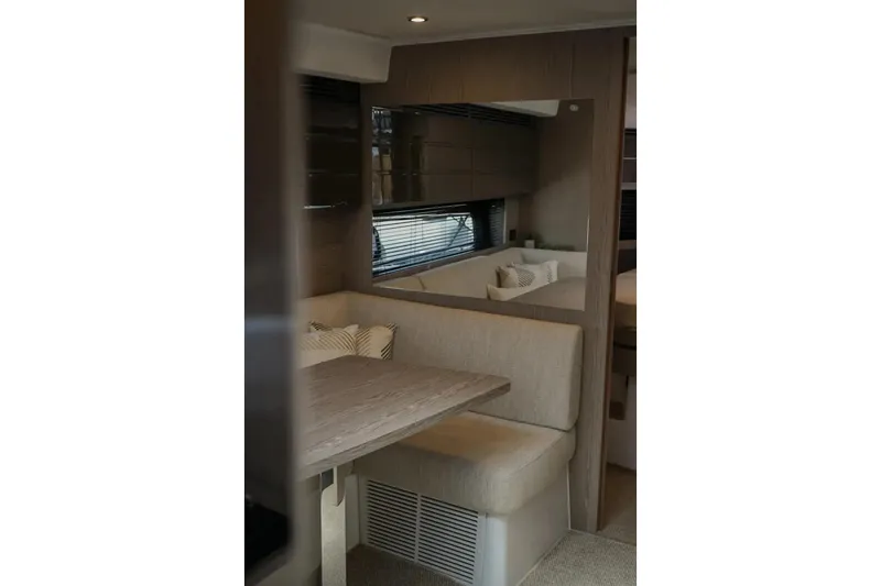  Yacht Photos Pics Interior of 2024 Azimut Atlantis 45 yacht, featuring a cozy dining area with beige seating.