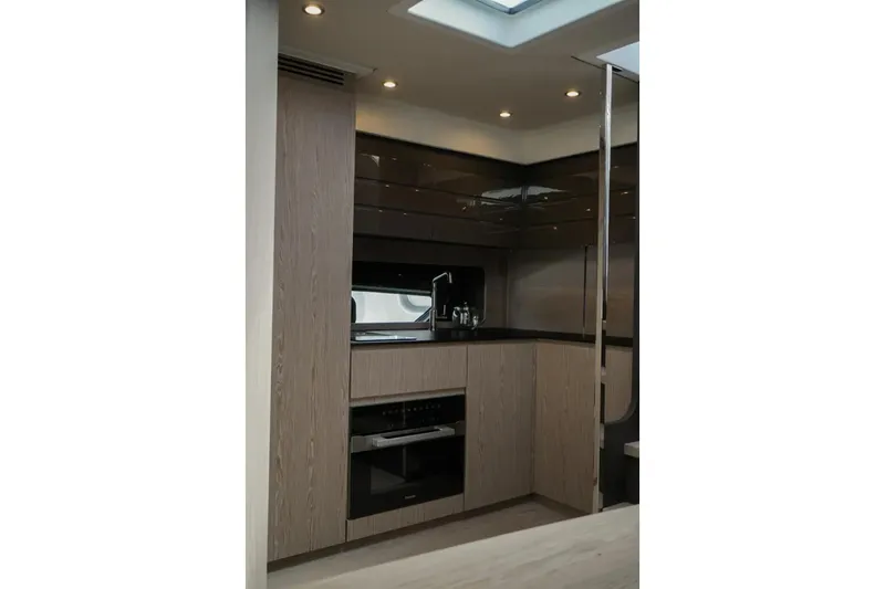  Yacht Photos Pics Modern kitchen interior of 2024 Azimut Atlantis 45 yacht, featuring sleek cabinetry and appliances.
