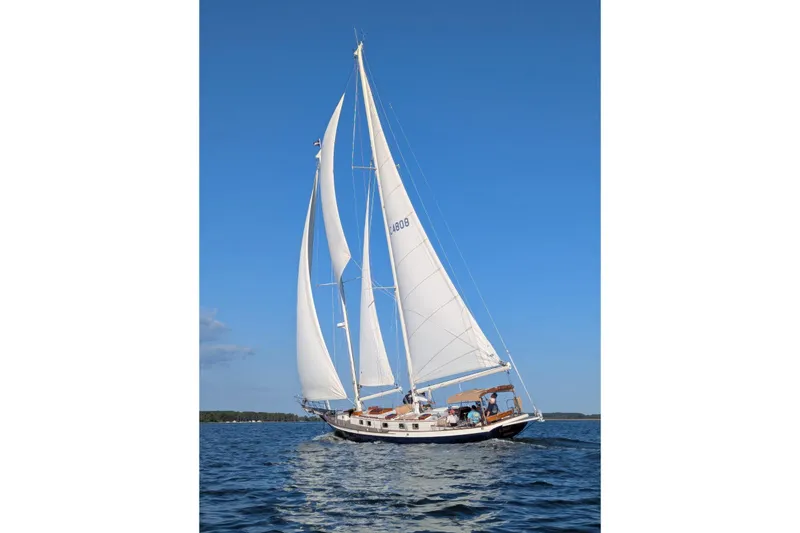 Light Reign Yacht Photos Pics Cherubini Schooner 2000 sailing on calm waters under clear blue skies.