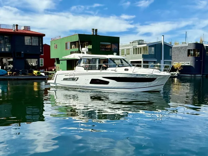  Yacht Photos Pics 2021 Jeanneau NC Weekender 1095 boat docked near colorful waterfront houses.