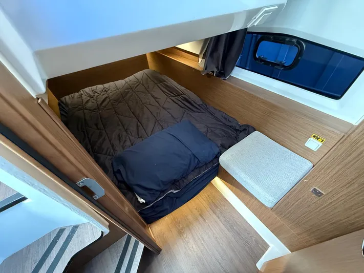  Yacht Photos Pics 2021 Jeanneau NC Weekender 1095 cabin interior with cozy bed and wooden finish.