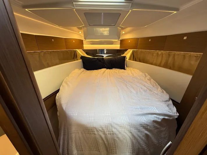  Yacht Photos Pics Cozy bedroom interior of 2021 Jeanneau NC Weekender 1095 boat with elegant bedding.