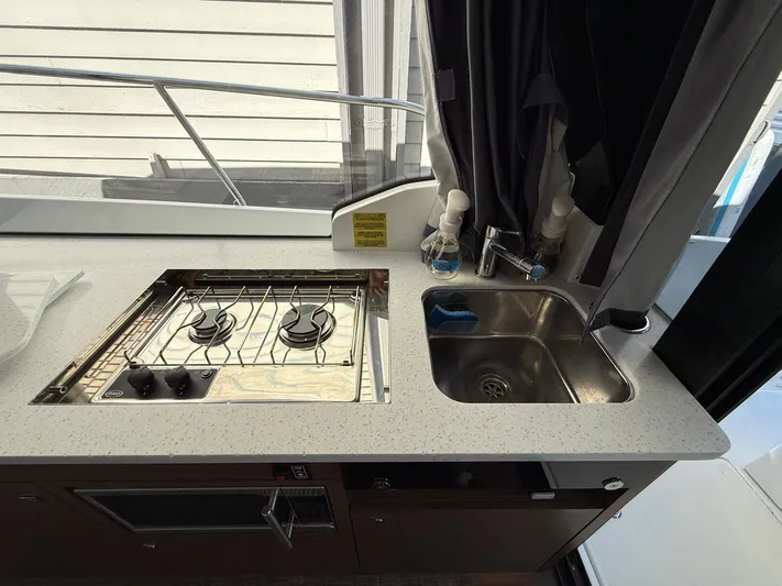  Yacht Photos Pics 2021 Jeanneau NC Weekender 1095 kitchen with stove and sink.