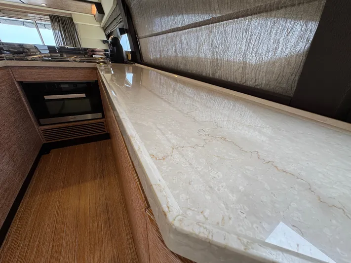 Miss Understood Yacht Photos Pics Luxurious kitchen interior of 2015 Azimut 64 yacht with marble countertop and modern appliances.