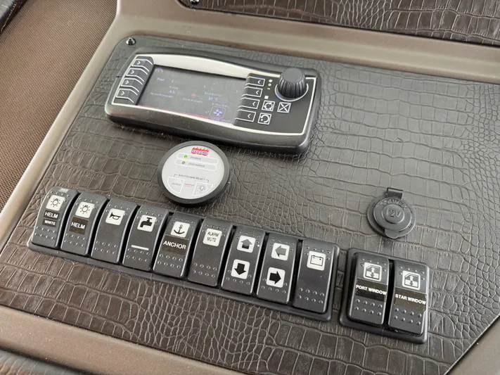 Miss Understood Yacht Photos Pics Control panel of a 2015 Azimut 64 yacht with various switches and a 12V outlet.