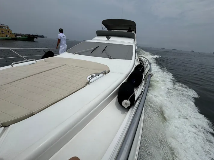 Miss Understood Yacht Photos Pics Luxurious 2015 Azimut 64 yacht cruising on open water, featuring sleek design and spacious deck.