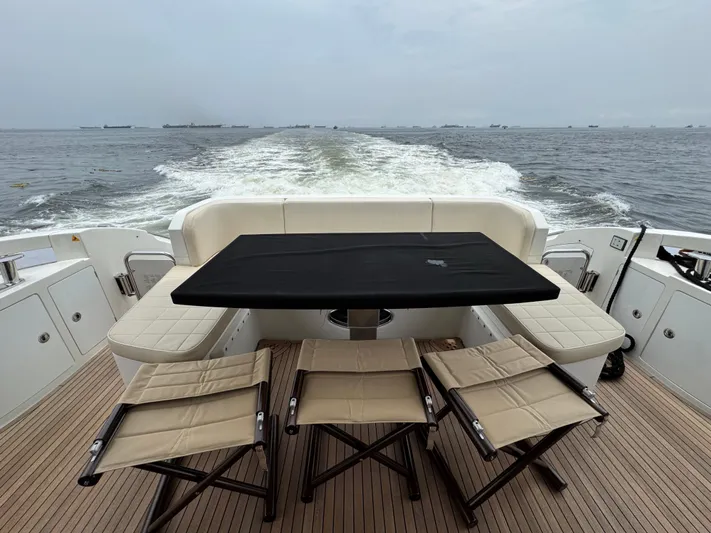 Miss Understood Yacht Photos Pics Luxury Azimut 64 yacht deck with seating, table, and ocean view, 2015 model.