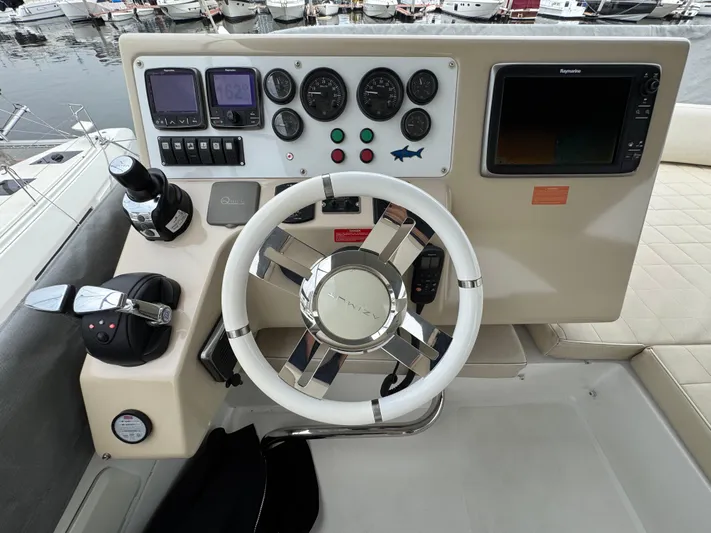 Miss Understood Yacht Photos Pics Helm of 2015 Azimut 64 yacht with steering wheel, gauges, and navigation equipment.