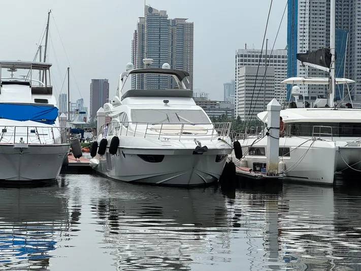 Miss Understood Yacht Photos Pics 2015 Azimut 64 yacht docked in a marina with city skyline backdrop.