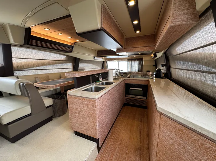 Miss Understood Yacht Photos Pics Luxurious interior of a 2015 Azimut 64 yacht featuring a modern kitchen and dining area.