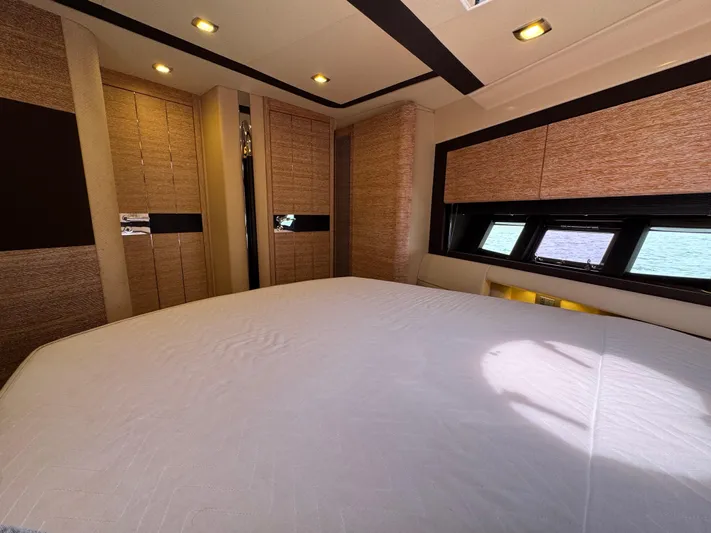 Miss Understood Yacht Photos Pics Luxurious bedroom interior of 2015 Azimut 64 yacht with elegant wood paneling and ocean view windows.