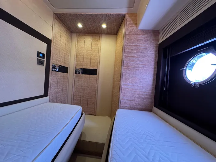 Miss Understood Yacht Photos Pics Luxurious cabin interior of 2015 Azimut 64 yacht with twin beds and porthole window.