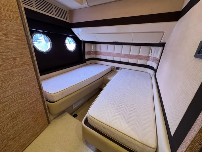 Miss Understood Yacht Photos Pics Luxurious twin cabin interior of 2015 Azimut 64 yacht with porthole windows.