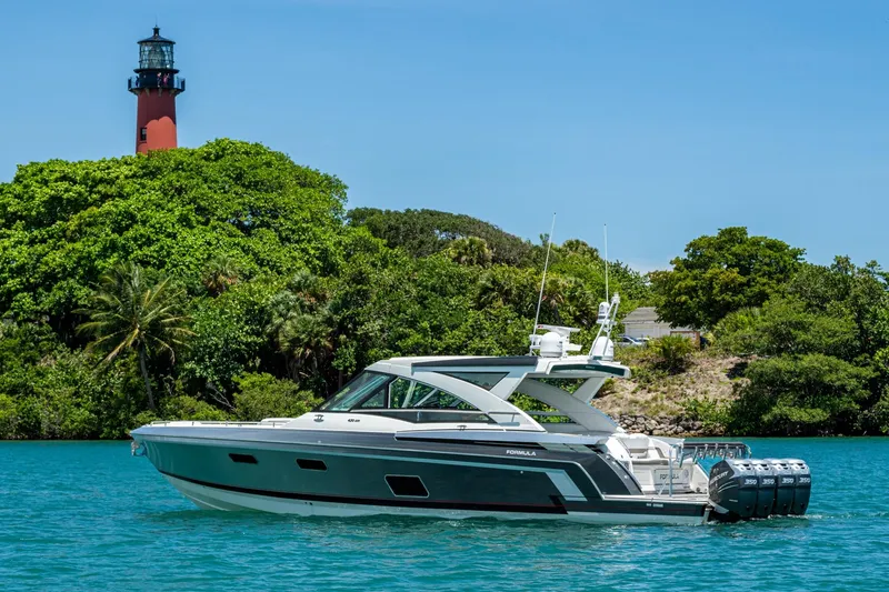  Yacht Photos Pics 2019 Formula 430 Super Sport Crossover yacht near a lush island and lighthouse.