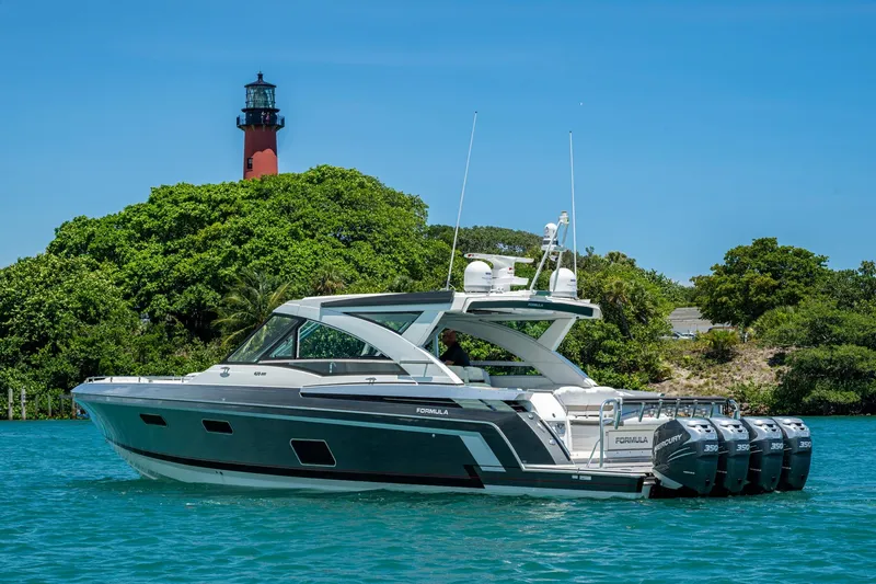  Yacht Photos Pics 2019 Formula 430 Super Sport Crossover yacht near a lighthouse, surrounded by lush greenery.