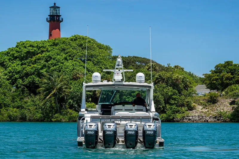  Yacht Photos Pics 2019 Formula 430 Super Sport Crossover boat cruising near a lighthouse and lush greenery.